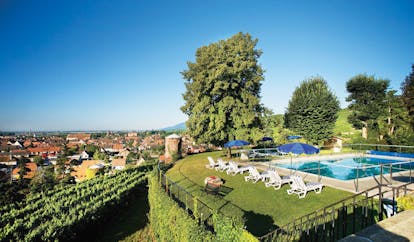 Chateau d'Isenbourg Alsace outdoor pool with loungers and umbrellas with countryside views