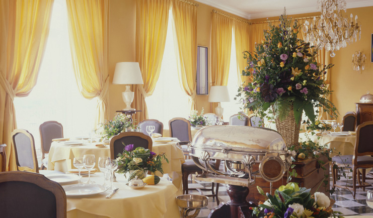 Chateau d'Isenbourg Alsace restaurant indoor dining area with chandelier and large floral arrangement