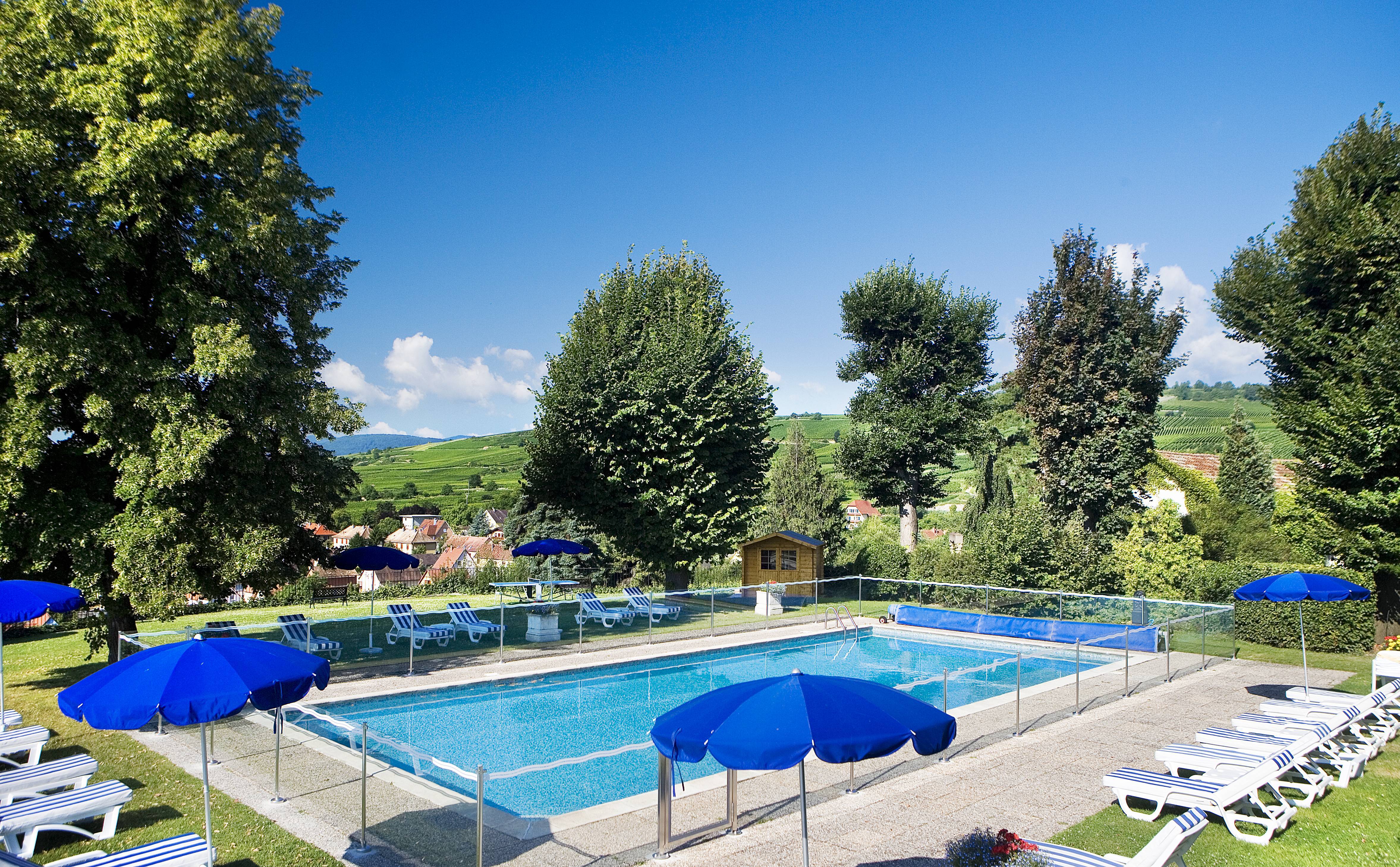 Chateau d'Isenbourg blue umbrellas next to outdoor swimming pool