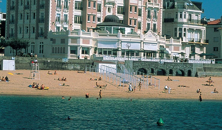 Grand Hotel Basque Country beach pink building overlooking the beach and beachgoers 