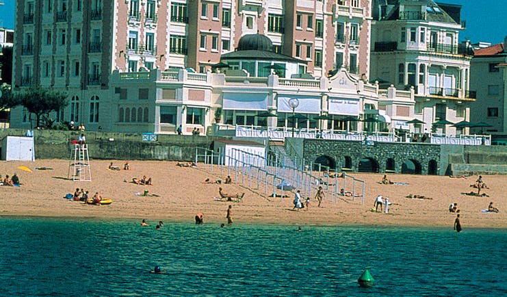Grand Hotel Basque Country beach pink building overlooking the beach and beachgoers