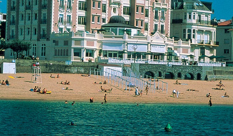 Grand Hotel Basque Country beach pink building overlooking the beach and beachgoers 