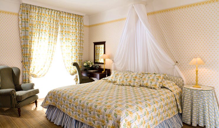 Grand Hotel Basque Country privilege bedroom with yellow and white curtains and white drape