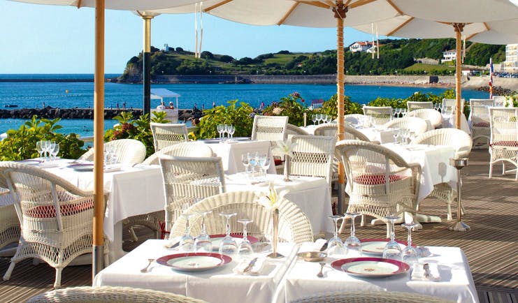 Grand Hotel Basque Country Terasse Rosewood outdoor dining area with umbrellas and sea view