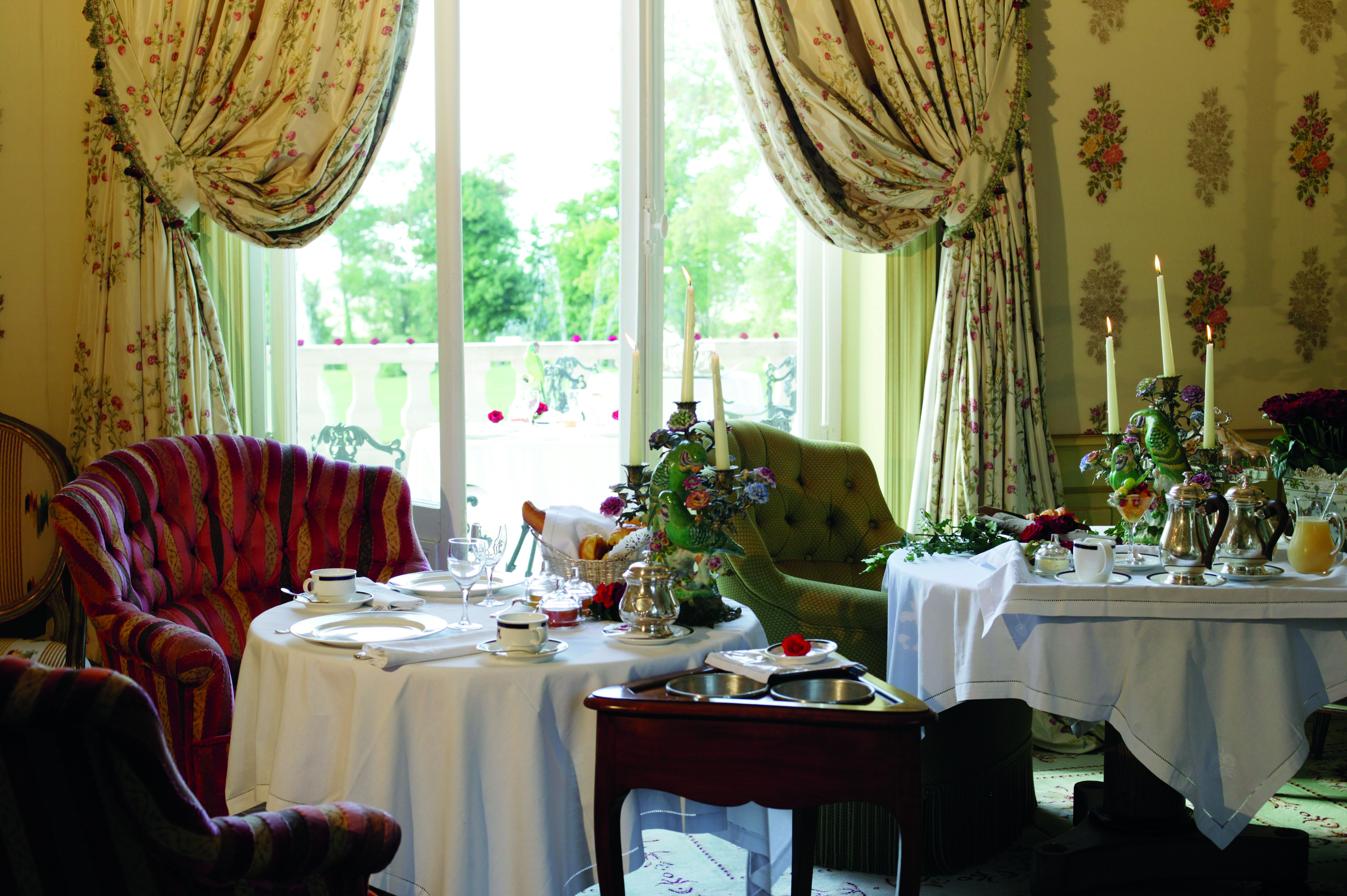 Chateau de Mirambeau breakfast room, indoor dining area with armchairs, tables set with afternoon tea, traditional grand architecture