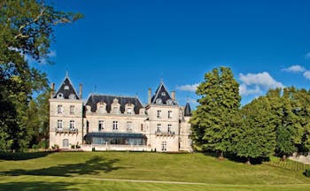 Chateau de Mirambeau exterior, grand hotel building, traditional chateau architecture, grass lawn, trees