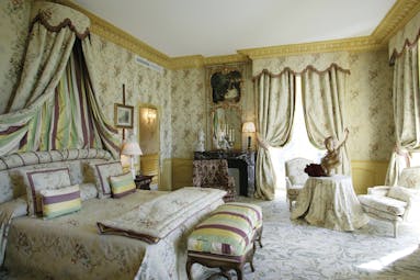 Chateau de Mirambeau junior suite, bed, seating area, grand traditional decor with draped curtains