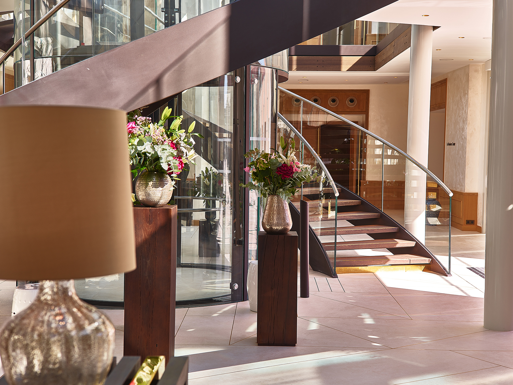 Lobby with staircase and flowers at Chais Monnet Cognac