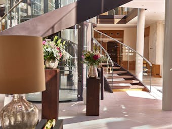 Lobby with staircase and flowers at Chais Monnet Cognac