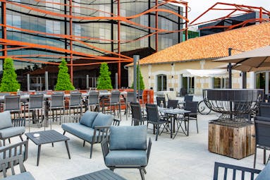 Outdoor bar area with grey seats at Chais Monnet Cognac