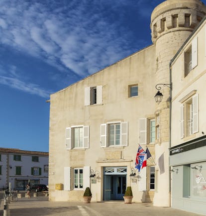 Hotel de Toiras cream building with tower and flags