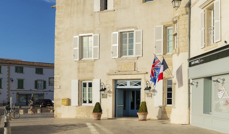 Hotel de Toiras cream building with tower and flags