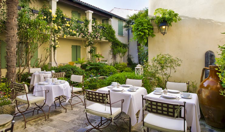 Hotel de Toiras shady terrace with dining chairs and tables
