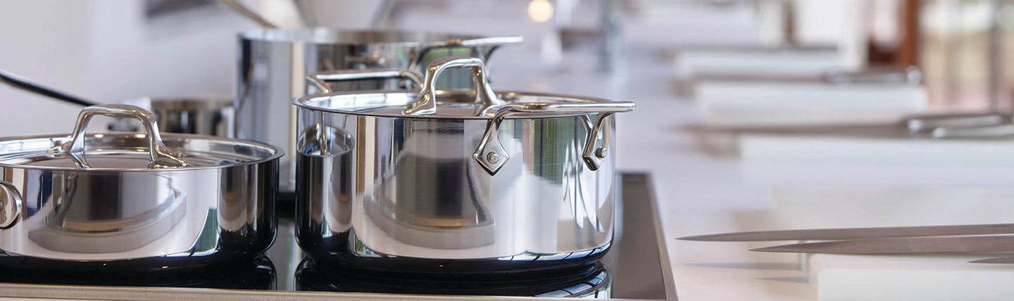 Silver pots on a hob for cookery lesson