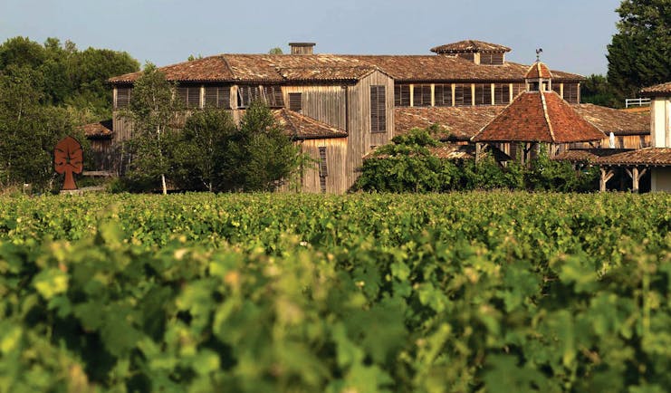 View of the hotel from afar with red topped roods and green field in front