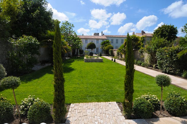 Villa Clarisse view of low pale house at end of long grassy gardens