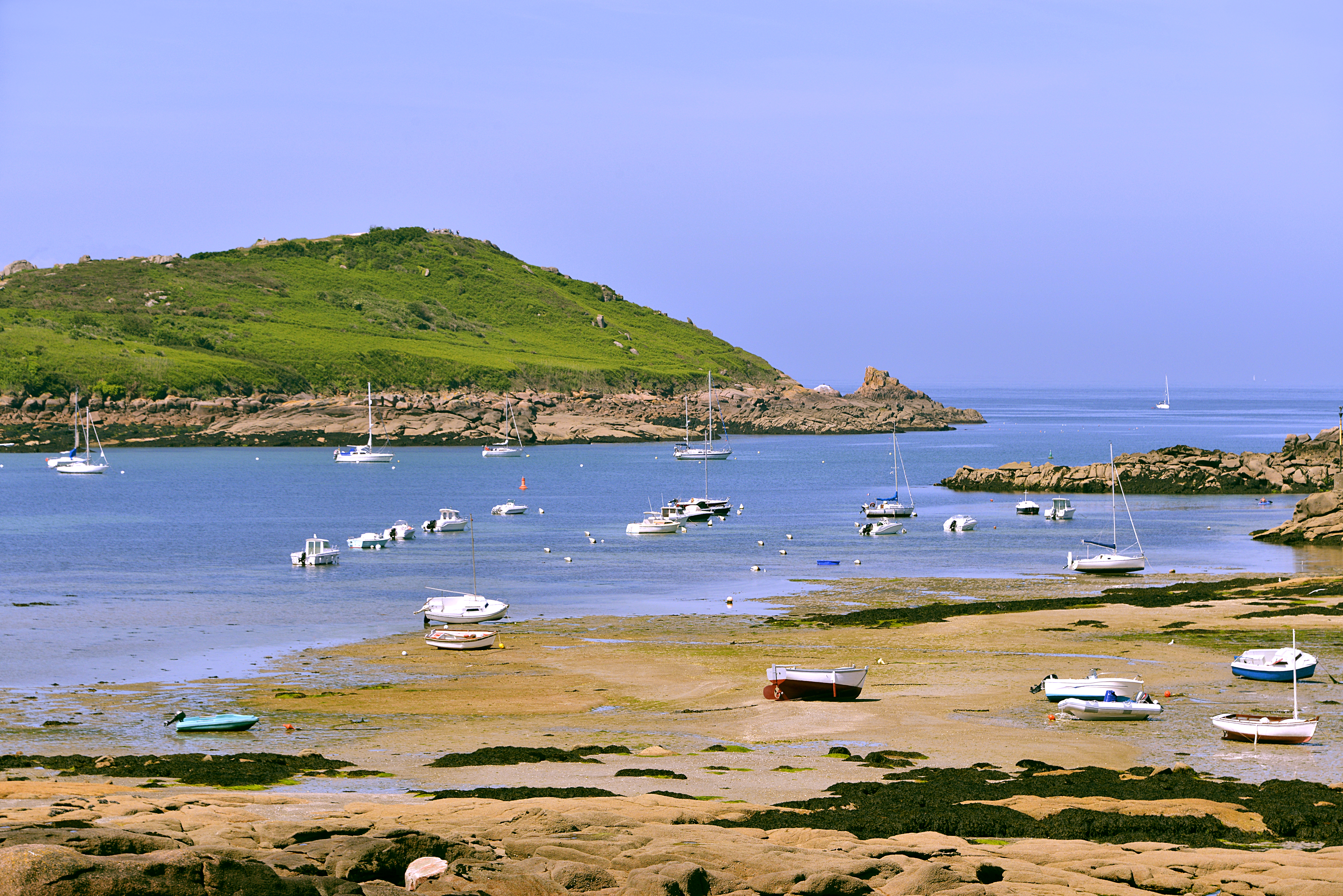Coast with beach and boats on pink granite coast near Trebeurden