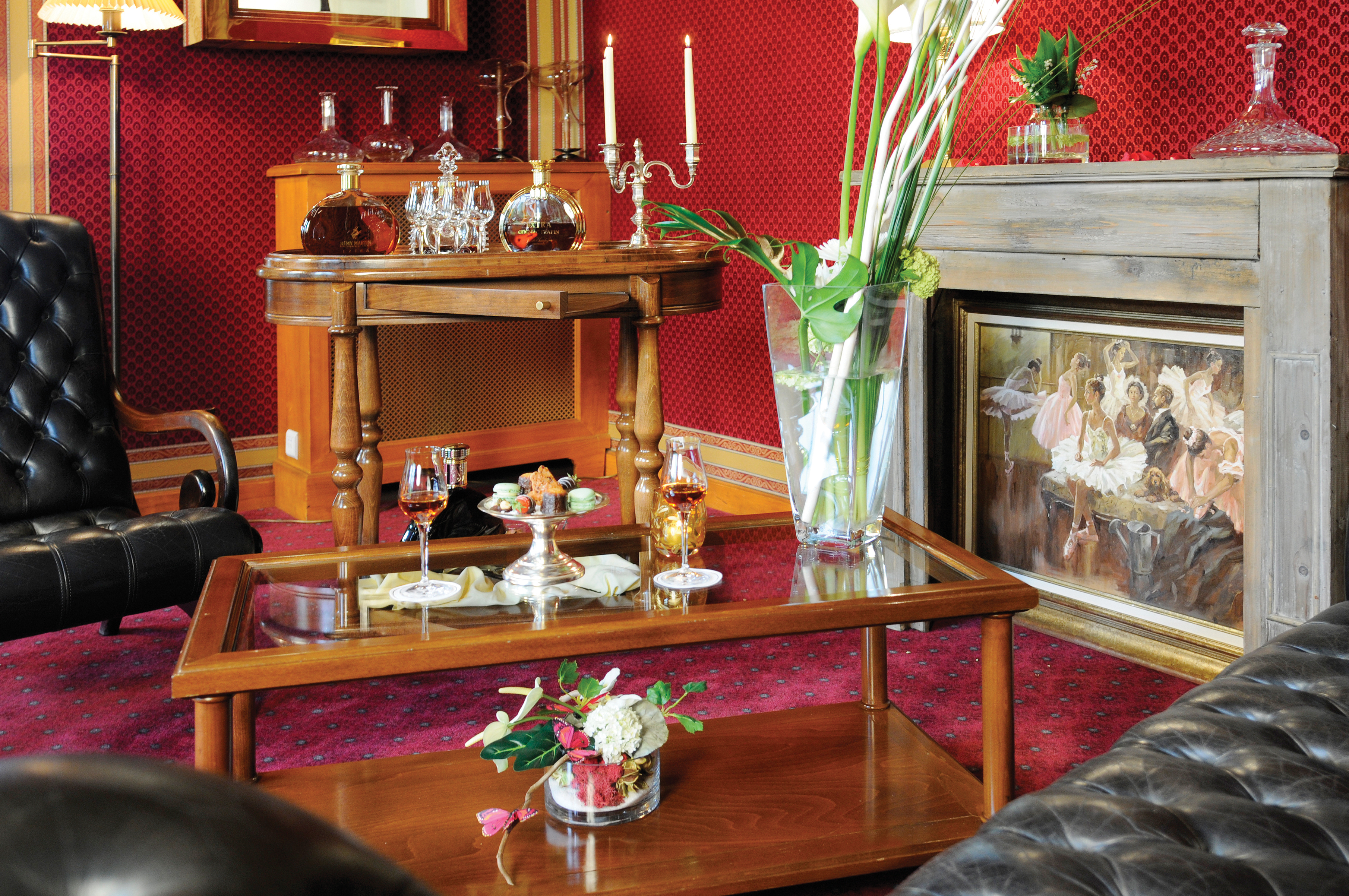 Afternoon tea lounge room with leather chairs set out and afternoon tea laid out on the coffee table in front next to the fireplace