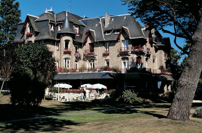 Castel Marie Louise Brittany exterior building with grey roof and view of gardens and outdoor dining area