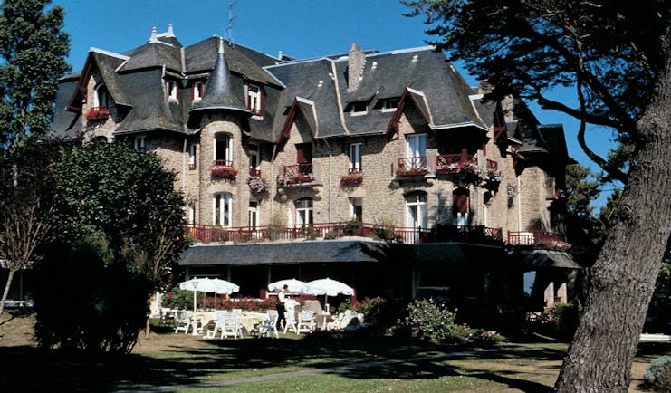 Castel Marie Louise Brittany exterior building with grey roof and view of gardens and outdoor dining area