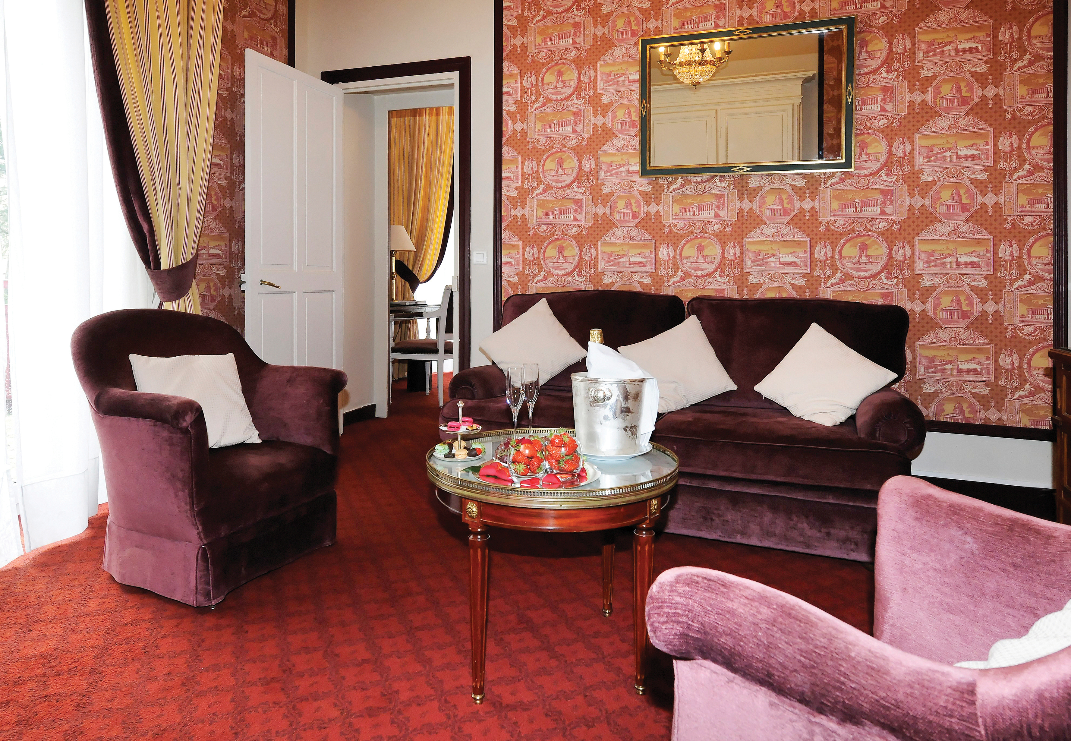 Lounge area with pink and purple colour scheme, with sofas and armchairs 