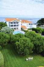 Hotel Anne de Bretagne Brittany exterior white building in front of the sea with swimming pool and trees