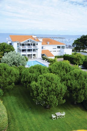 Hotel Anne de Bretagne Brittany exterior white building in front of the sea with swimming pool and trees