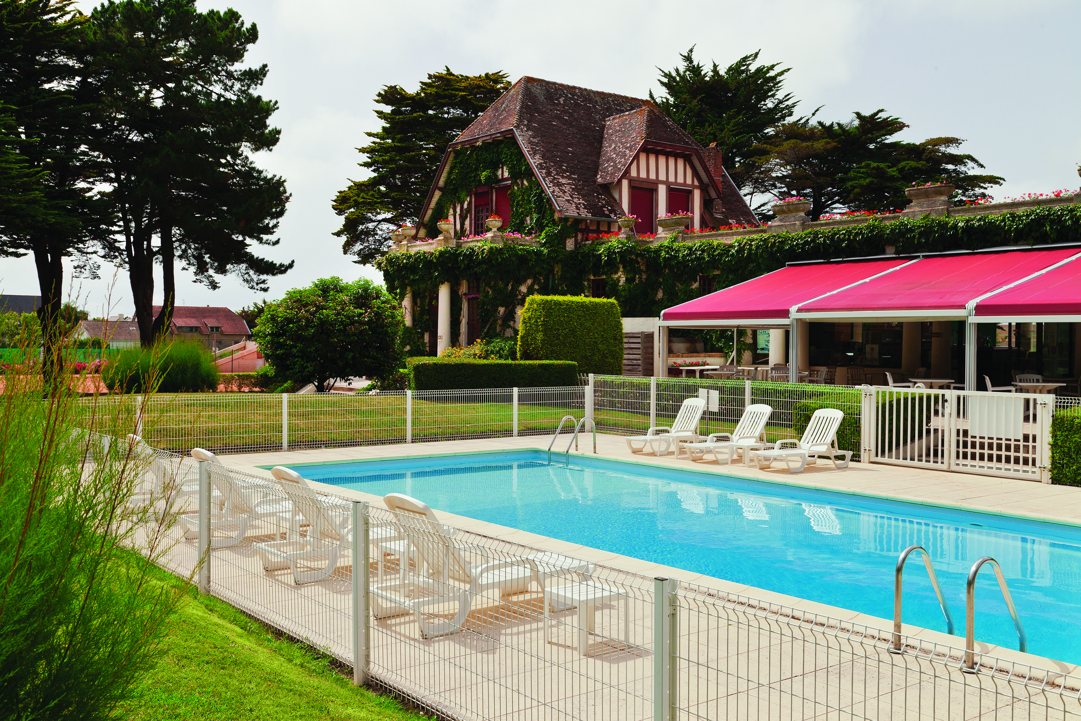 Hotel Hermitage Barriere Brittany exterior pool with loungers near an old building and a terrace area