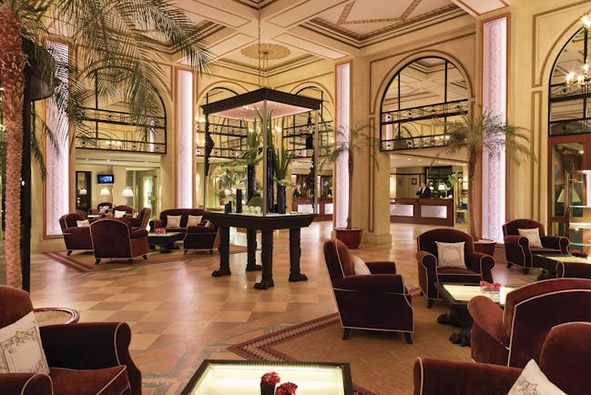 Hotel Hermitage Barriere Brittany lobby area with palm trees and armchairs