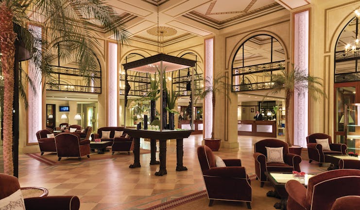 Hotel Hermitage Barriere Brittany lobby area with palm trees and armchairs