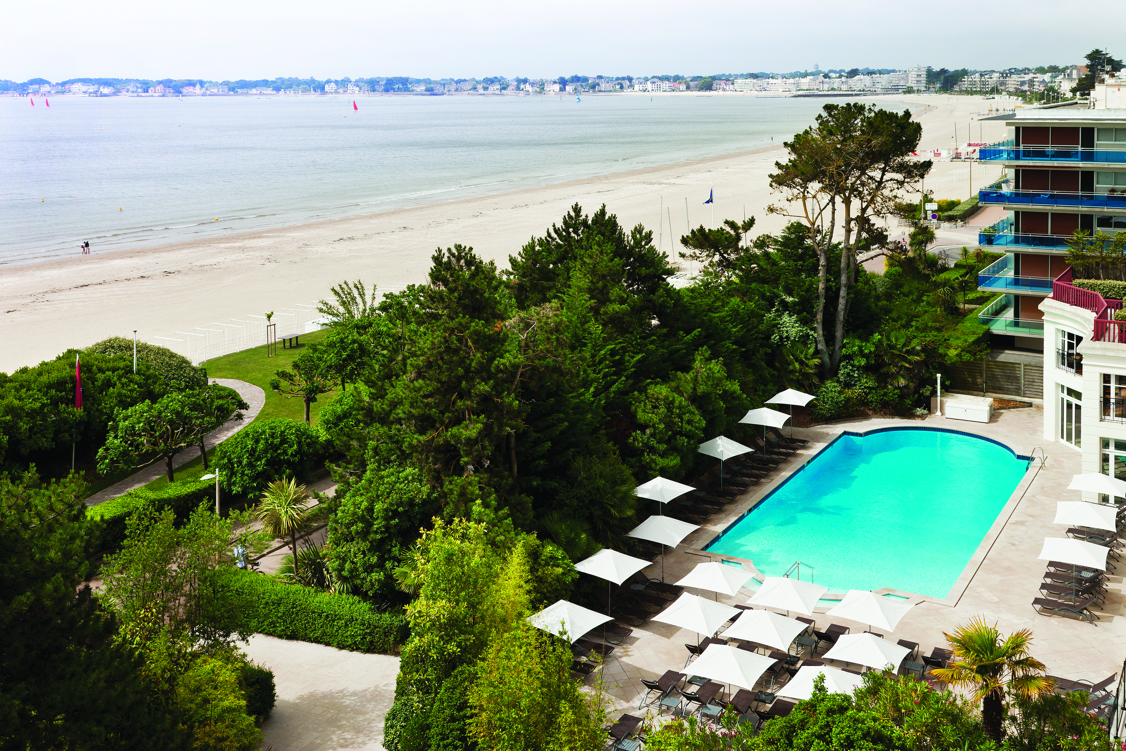 Hotel Hermitage Barriere Brittany outdoor pool facing onto the beach with sun loungers and umbrellas