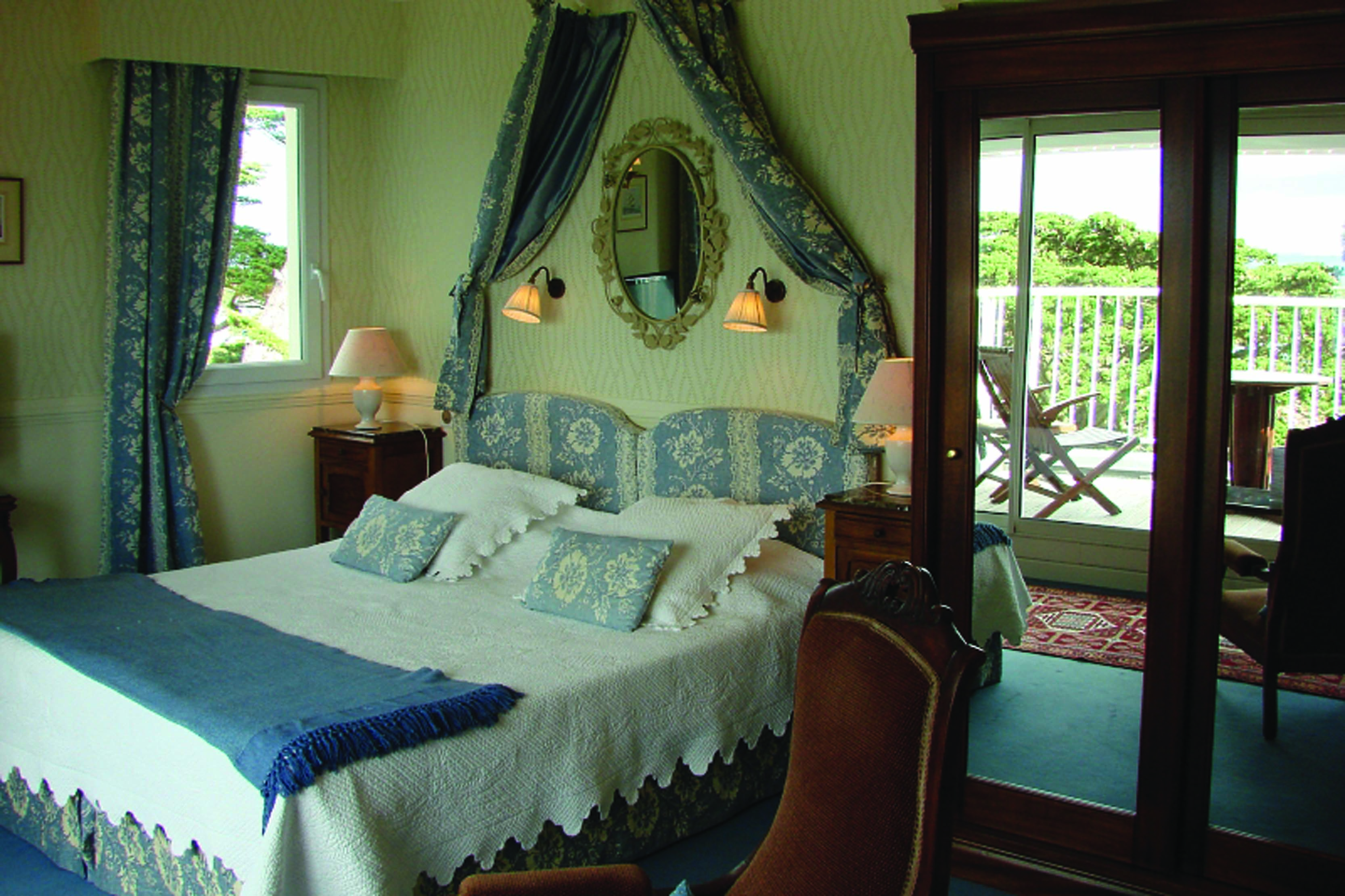 Bedroom with large double bed, windows leading out onto a terrace balcony