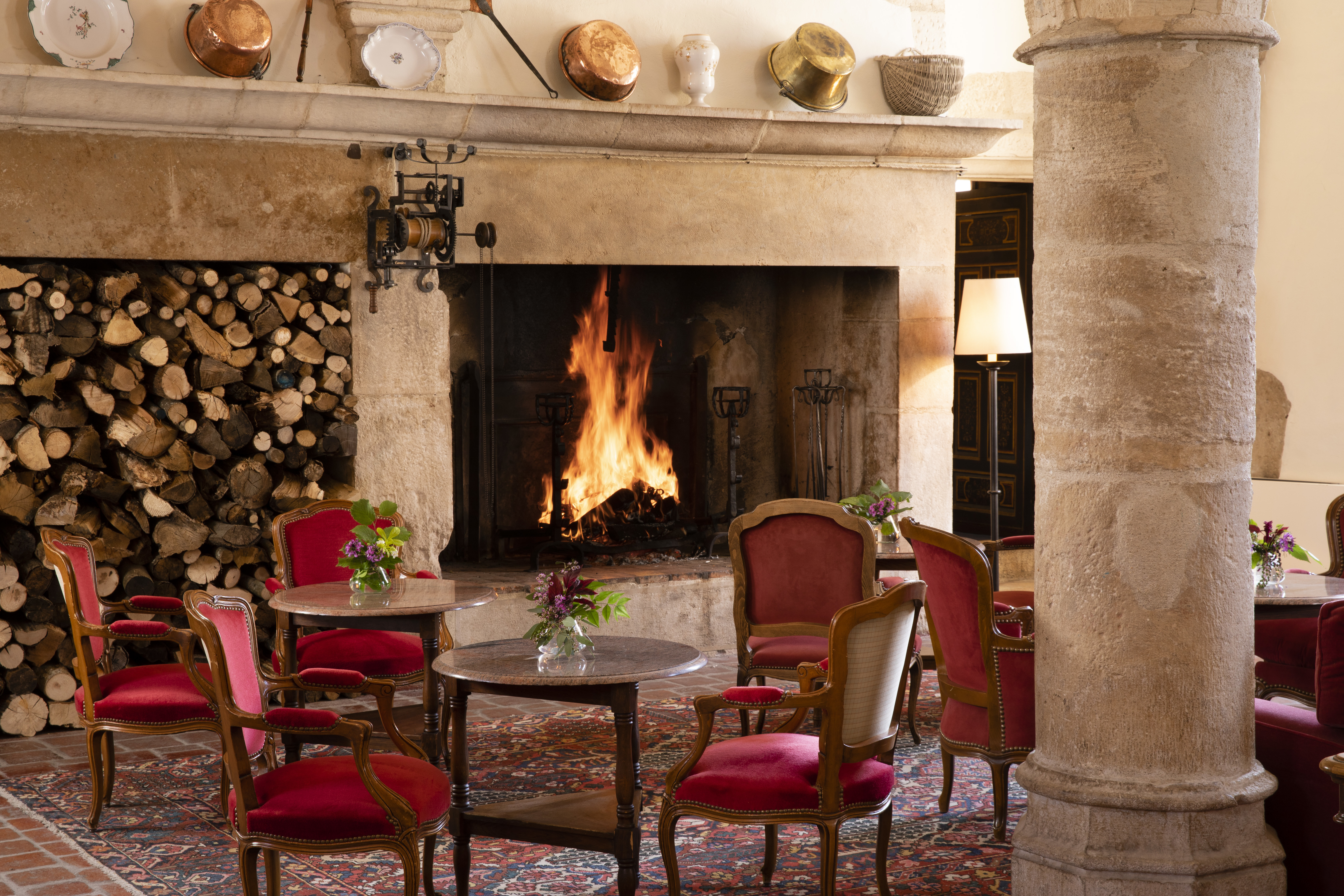 Chateau de Gilly bar with large fireplace and red chairs