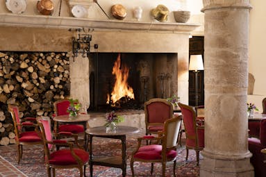 Chateau de Gilly bar with large fireplace and red chairs