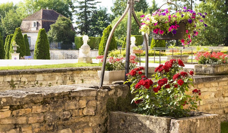 Chateau de Gilly gardens with red roses in stone tub