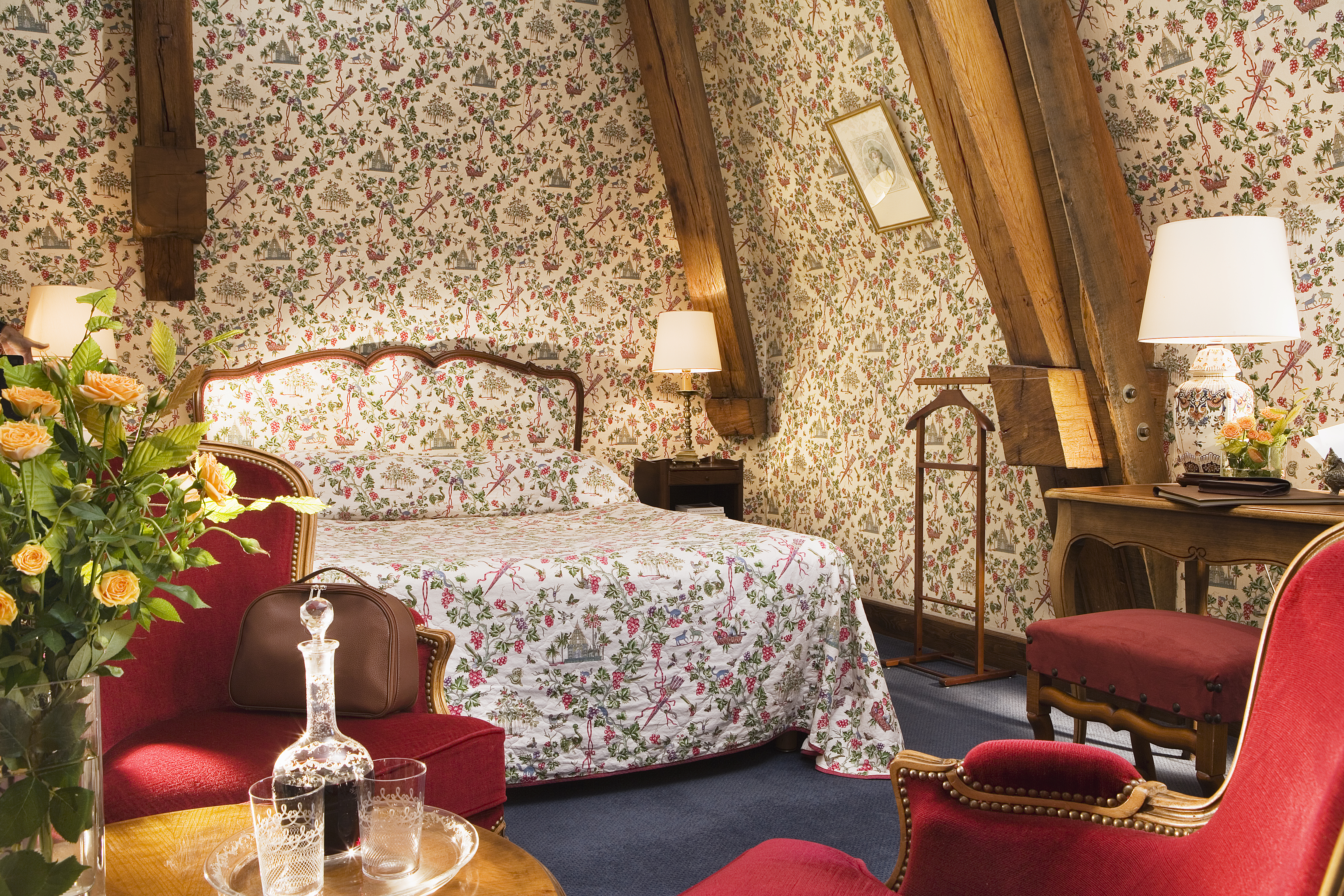 Chateau Gilly Burgundy tradition bedroom with floral wallpaper a wooden desk and an armchair