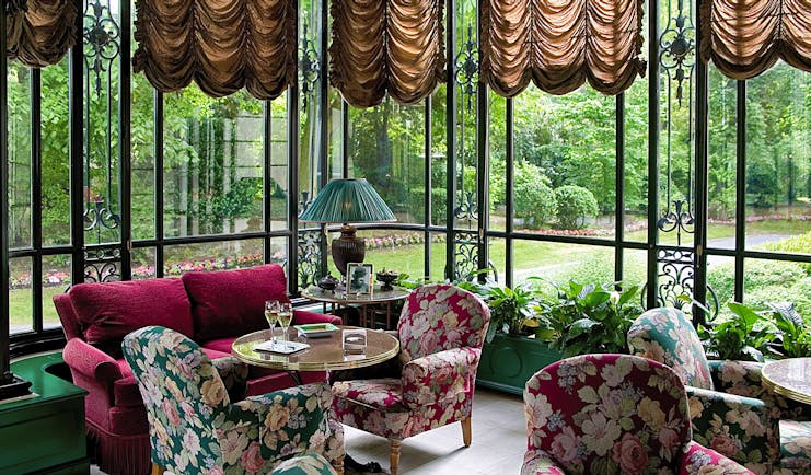 Lounge area with chairs and sofas looking over the gardens