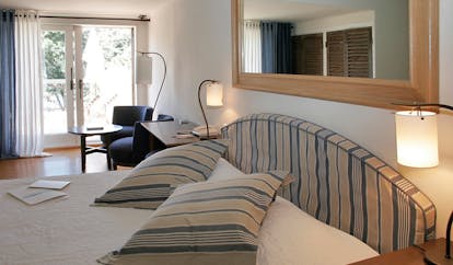 Grand Hotel de Cala Rossa Corsica Capucine room bedroom with blue and white head board and patio doors to balcony
