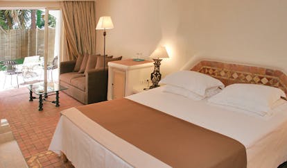 Grand Hotel de Cala Rossa Corsica eglantine room bedroom with sofa and patio access