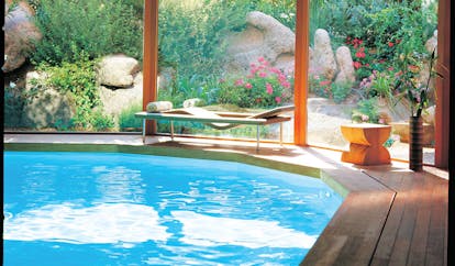 Grand Hotel de Cala Rossa Corsica indoor pool with garden view and lounger