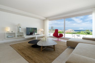 Lounge area with modern decor, flat screen television and corner sofa looking over terrace