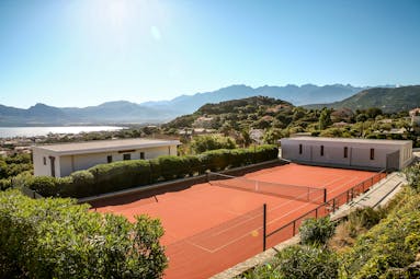 Tennis court with view of sea and mountains in the distance