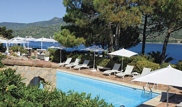 Miramar Boutique Hotel Corsica outdoor pool with sun loungers and large umbrellas