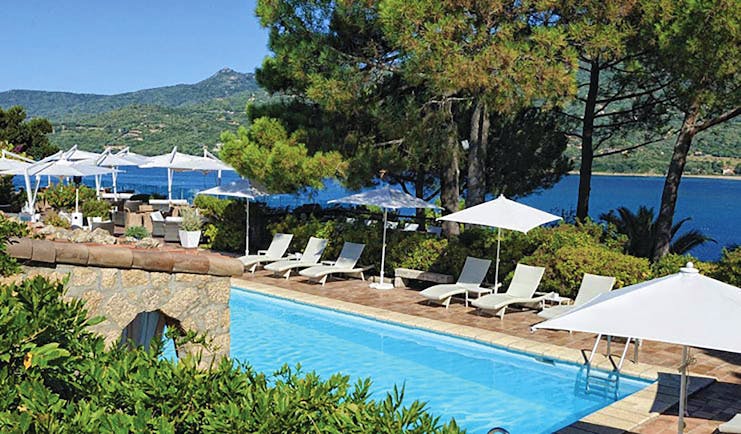 Miramar Boutique Hotel Corsica outdoor pool with sun loungers and large umbrellas