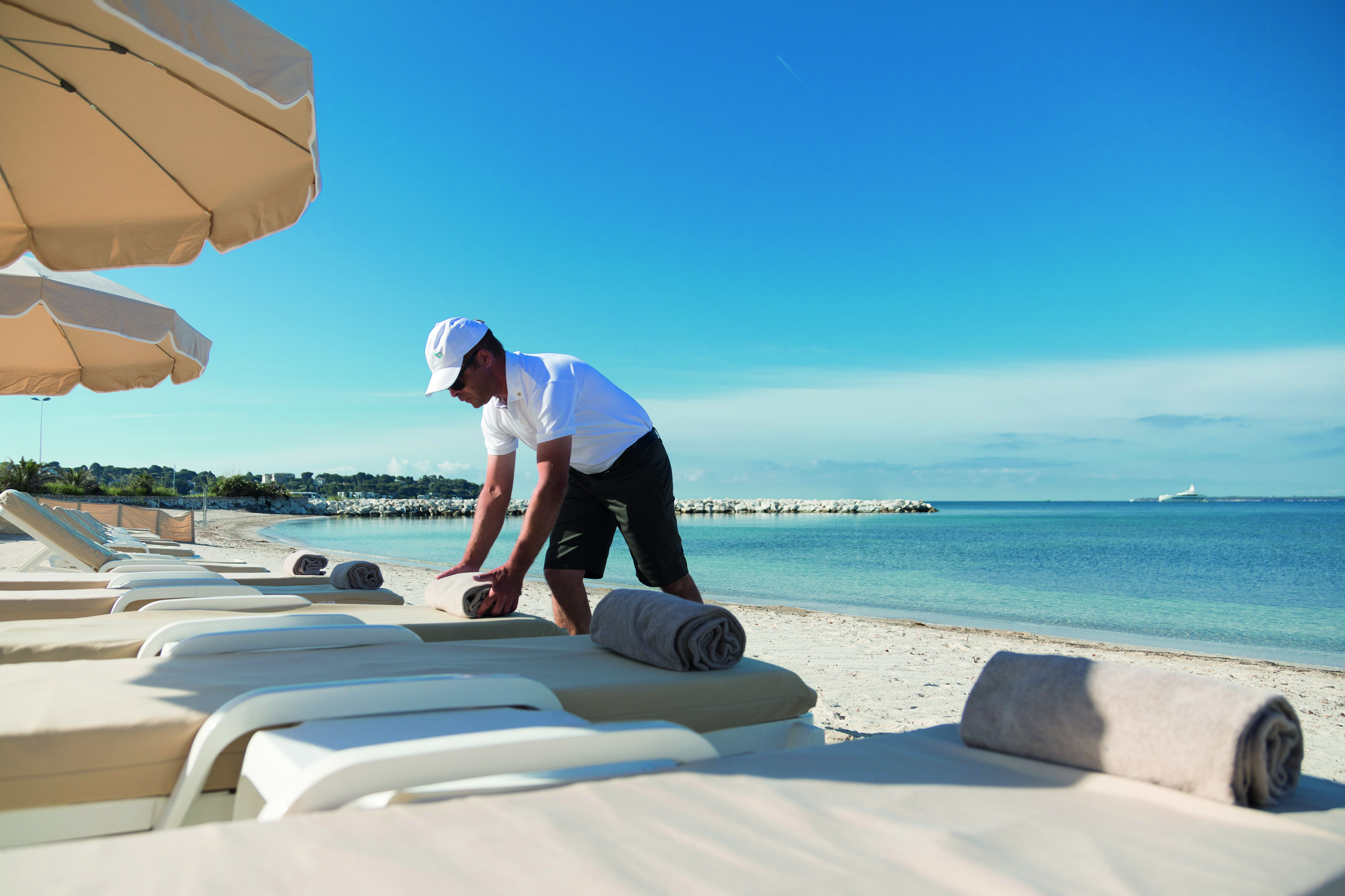 Le Cap d'Antibes Beach Hotel Cote d'Azur beach view man arranging towels on sun lounger