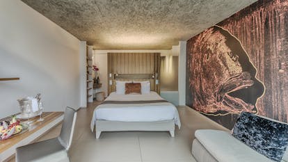Le Cap d'Antibes Beach Hotel Cote d'Azur deluxe bedroom with desk and large painting of a fish on the wall