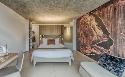 Le Cap d'Antibes Beach Hotel Cote d'Azur deluxe bedroom with desk and large painting of a fish on the wall