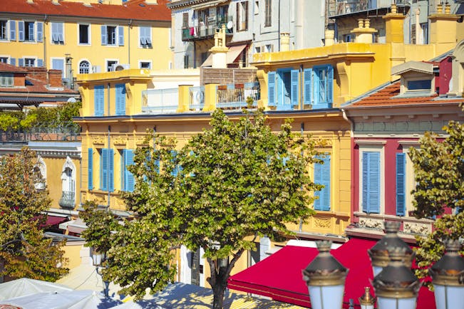 Yellow houses with blue shutters in flower market Nice