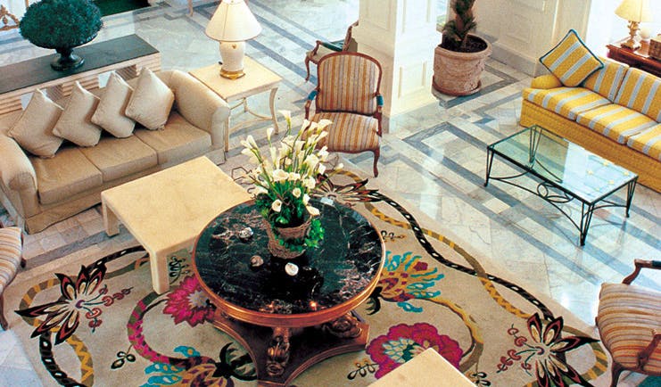 Grand Hotel du Cap Ferrat lobby area with sofas floral rug and floral arrangement