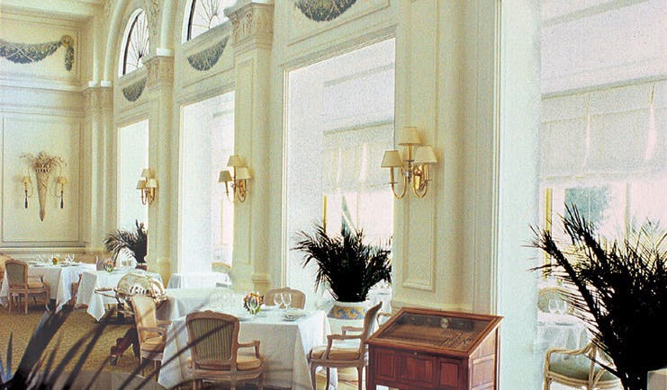 Grand Hotel du Cap Ferrat restaurant indoor dining area with large windows and plants